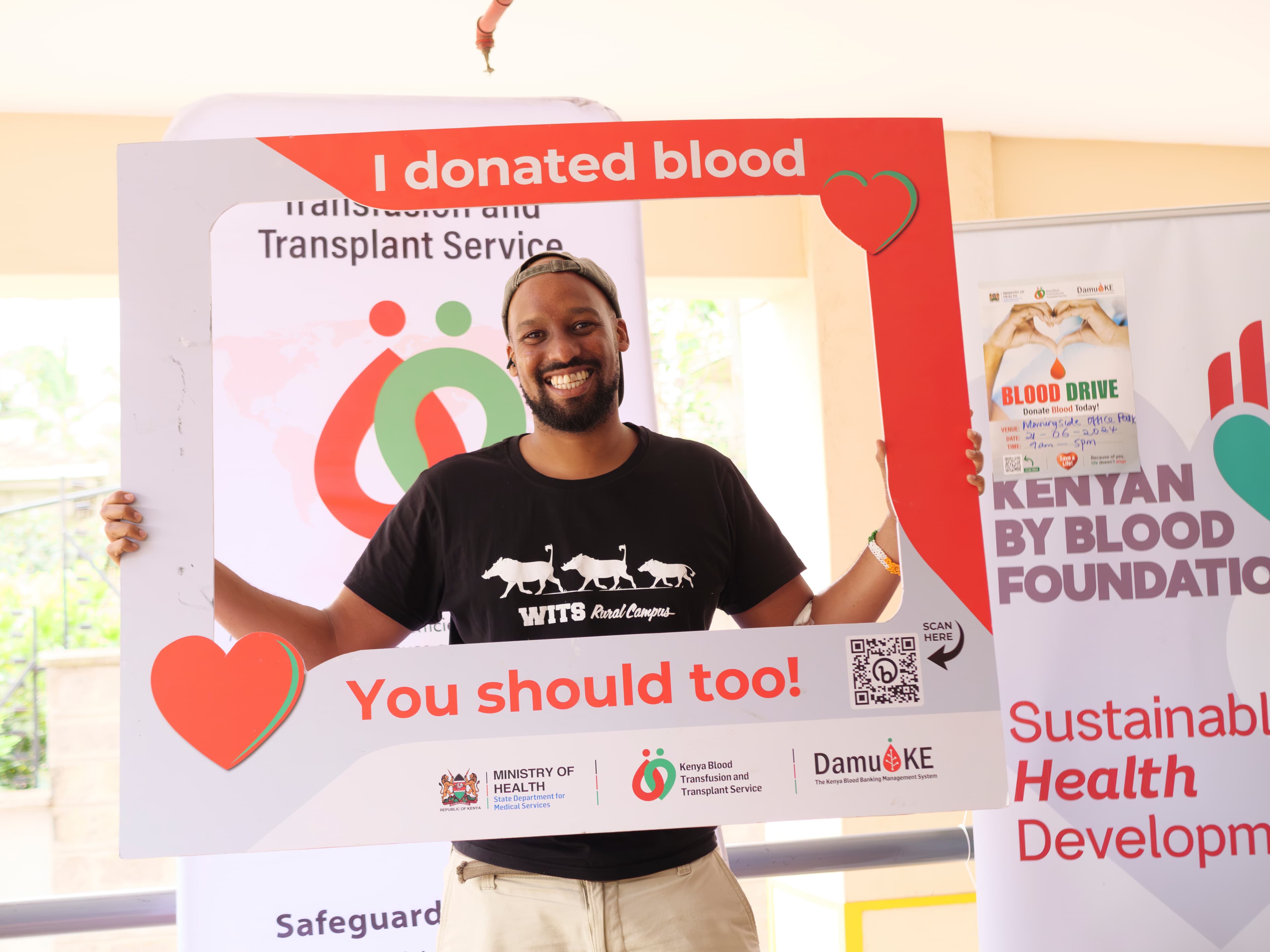 A young Kenyan man holding a placard after donating blood
